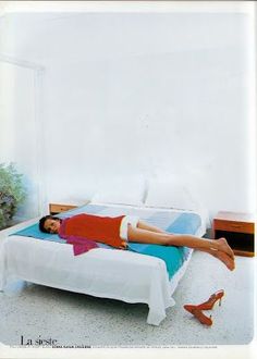 a woman laying on top of a bed with high heels