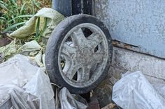 One old dirty plastic gray black wheel from a trolley lies on a pile of garbage stock images Black Wheels, Wheel, Stock Photos, Grey, Black