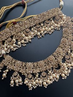 This is a gorgeous complete bridal set that comes with 3 layered necklaces, earrings, nath, mathapatti, passa and hand jewelry. It is made of real polki stones and the pieces can be worn seperately for a lighter look. The set comes in 3 colors with rose gold, pink and gold finish and is neutral enough to match any outfit! Grab this set for your big day and create a royal look! Luxury Temple Jewelry Sets For Reception, Luxury Temple Jewelry Sets For Wedding, Luxury Hand Set Temple Jewelry Sets, Indian Bridal Choker, 3 Layer Necklace, Jewelry Kundan, Kundan Necklace Set, Bridal Choker, Royal Look