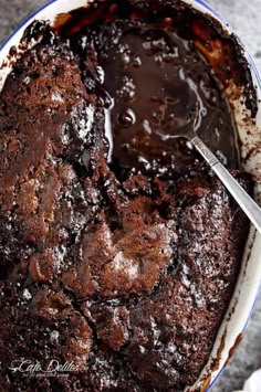 a chocolate cake in a blue and white bowl with a spoon sticking out of it