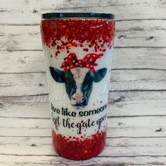 a red glitter tumbler with a cow on it