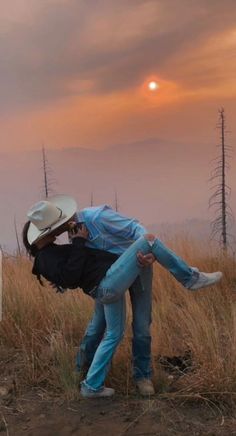 two people are hugging in the middle of a field