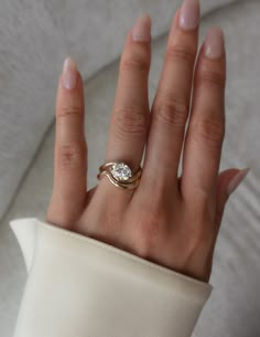 a woman's hand wearing a gold ring with a diamond on the middle and side