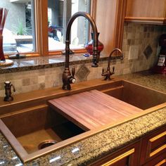 a kitchen sink with a wooden cutting board in it