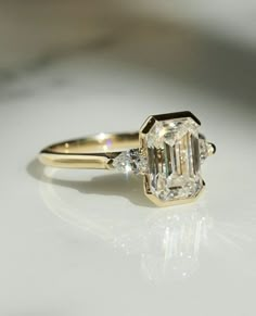 an engagement ring with a large diamond in the center and two smaller diamonds on each side