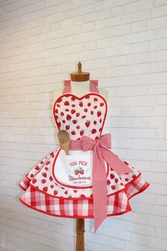 a dress made out of red and white checkered fabric with an apron on it