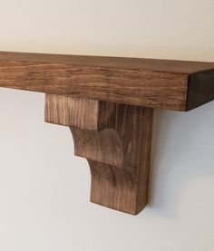 a wooden shelf mounted to the side of a wall