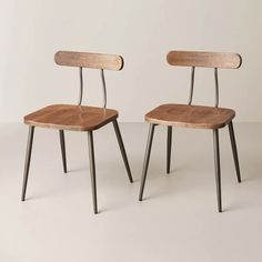 two wooden chairs sitting next to each other