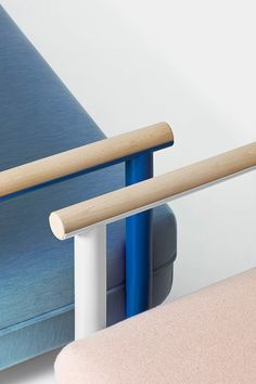 two blue and pink chairs next to each other on a white surface with wooden handles