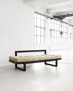 an orange bench sitting on top of a hard wood floor next to a white wall