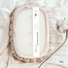 an empty white tray sitting on top of a bed next to a small stuffed animal