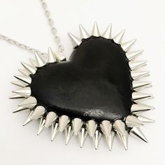 a heart shaped necklace with spikes on it