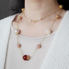 🍂 Long Chain Necklace ❀ Gold Plated Chain and Clasp ❀ Gold and Rose Gold Plated Brass Filigree Ball❀ Natural Carnelian 15mm and Sakura Agate 8mm❀ Natural Baroque Pearl 13mm and Wire Wrapped Seed Pearls Ball 14mm❀ Length 34 Inch (86cm) Inspired by the warm, earthy tones of autumn, this long chain necklace combines the vibrant hues of natural carnelian and sakura agate with the elegance of baroque pearls. The gold and rose gold-plated brass filigree balls add a touch of intricate detail, while th Studded Necklace, Velvet Choker, Long Chain Necklace, Long Chain, Jade Stone, Coral Turquoise, Pearl Gemstone, Gold Plated Chains, Baroque Pearls