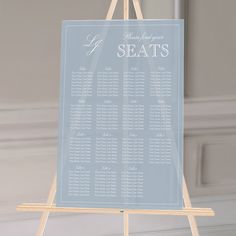 a wooden easel holding a seating chart for a wedding or special event in blue and white