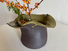 a vase with orange flowers in it sitting on a table