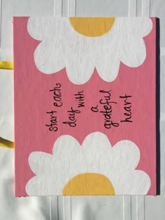 a pink and white card with daisies on it