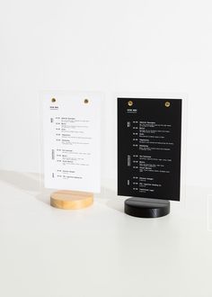 a black and white menu sitting on top of a table next to a wooden stand