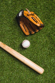 a baseball bat, glove and ball on the grass