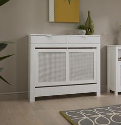 a white cabinet sitting next to a rug on top of a hard wood floor