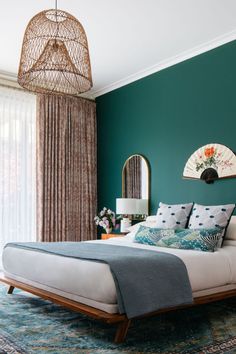 a bedroom with teal walls and a large bed in the middle, surrounded by curtains