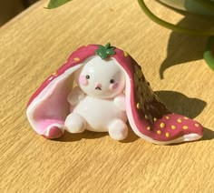 a small figurine sitting on top of a table next to a potted plant