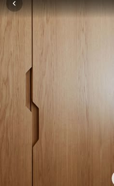 a close up of a wooden cabinet door with holes in the wood and an arrow pointing to it