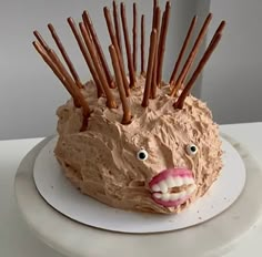 a cake shaped like a hedgehog with sticks sticking out of it's mouth