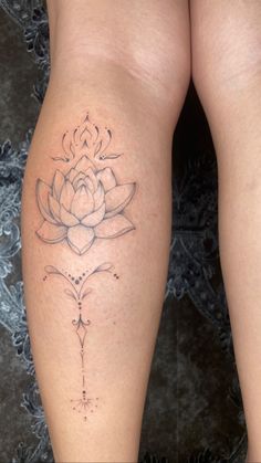 a woman's leg with a tattoo on it that has a flower in the center