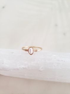 This dainty and feminine freshwater pearl ring is classic, minimal and beautiful! Pairs well with other rings or on its own. Genuine freshwater pearl is lovingly wrapped onto a hand formed and hammered band. The hammering gives lovely shimmery texture and also adds strength to the band! Made from top quality materials - true 14k gold fill or solid sterling silver - will not turn your finger green or wear off. Wear 24/7! Lead and nickel free. Excellent for sensitive skin. Comes packaged in a box Handmade Dainty Pearl Open Ring, Dainty Handmade Pearl Open Ring, Dainty Pearl Promise Ring With Birthstone, Dainty Pearl Birthstone Promise Ring, Dainty Stackable Pearl Promise Ring, Dainty Tiny Pearl Promise Ring, Dainty Tiny Pearl Ring, Dainty 14k Gold Filled Wire Wrapped Rings, Delicate Stackable Pearl Ring For Promise