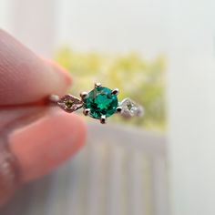 a person holding an emerald ring in their hand