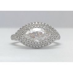 a white gold ring with an oval cut diamond surrounded by round brilliant pave diamonds