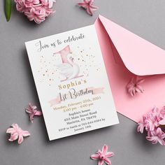 a pink and white swan birthday party card on top of an envelope next to flowers