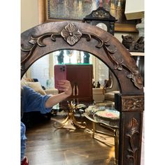 a person taking a selfie in front of a mirror with an ornate design on it