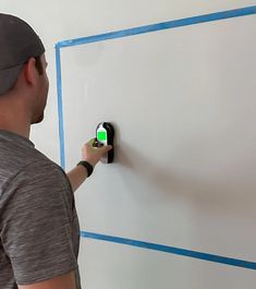 a man is using an appliance to control the light switch on a wall