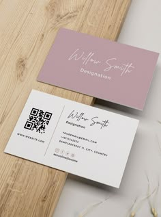 two business cards sitting on top of a wooden table