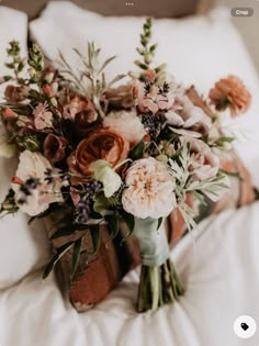 a bouquet of flowers is laying on the bed