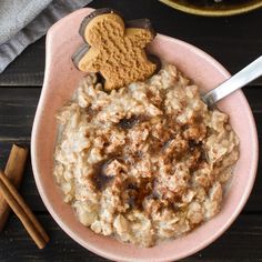 a bowl of oatmeal topped with cinnamon and an animal shaped cookie on top