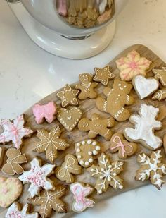 a wooden board topped with lots of cut out cookies