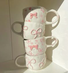 three coffee mugs stacked on top of each other in the shape of bow ties