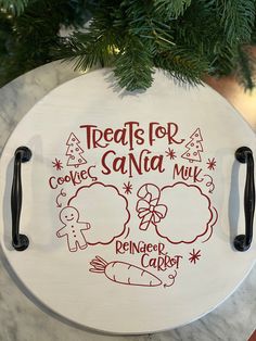 a christmas ornament hanging from a tree with the words treats for santa on it