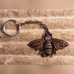 a close up of a key chain with a bee on it