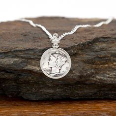 Introducing our exquisite Custom Date Dime Necklace, a perfect treasure to commemorate your loved one's special moments! Whether it's a birthday, anniversary, or any other occasion, this unique piece makes an extraordinary gift that will be cherished forever. Features and Details: - Adorned with an 18 inch sterling silver-plated curb chain, this necklace exudes elegance and is designed to be comfortably worn every day. - The dime is bezel mounted, ensuring lasting protection while enhancing the beauty of the coin. - Each necklace is exclusively made to order, allowing you to create a truly personalized keepsake. Select the memorable year of any significant event. Capturing those precious memories has never been easier! We truly understand the importance of unforgettable moments. This Custo Classic White Gold Charm Necklaces For Anniversary, Classic White Gold Charm Necklace For Anniversary, Classic Charm Necklace For Anniversary, Nickel-free Heirloom Jewelry For Anniversary, Classic Nickel-free Jewelry For Mother's Day, Heirloom Nickel-free Jewelry For Anniversary, Anniversary Coin Pendant Jewelry, Anniversary Gift Coin Pendant Jewelry, Heirloom Jewelry Gift For Mother's Day