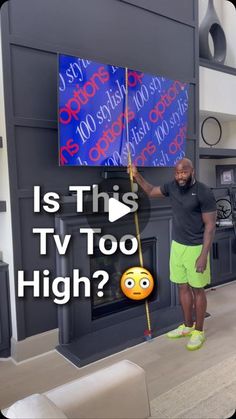 a man standing in front of a tv holding a flag with the words is this tv too high?