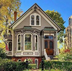 an old victorian style house with many windows and trimmings on the front porch