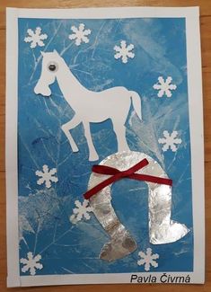 a paper cut out of a horse with snowflakes on it and ribbon around its neck