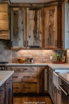 a kitchen with wooden cabinets and white marble counter tops, wood flooring and tile backsplash