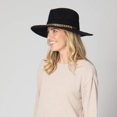 Introducing Jolene - the epitome of sophistication. Crafted from a luxurious wool blend, this fedora features a front gold chain and a faux leather band in the back. Its 3.5" brim size will keep you stylish and protected. Available in elegant black. Features: Color: Black Material: 60% Wool, 40% Polyester Size: 57cm Machine Knit Wool Blend Fedora Front Gold Chain and Back Faux Leather Band Brim Size: 3.5" Classic Gold Flat Brim Hat Band, Classic Gold Fedora With Short Brim, Classic Gold Hat Band For Fedora, Classic Gold Flat Brim Fedora, Classic Gold Fedora With Curved Brim, Elegant Adjustable Gold Fedora, Gold Fedora Hat For Winter, Classic Gold Brimmed Fedora, Gold Wide Brim Classic Fedora