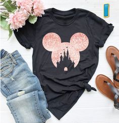 a black shirt with pink minnie mouse ears on it and some flowers next to it