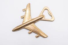 an airplane shaped brooch is shown on a white surface with no people around it