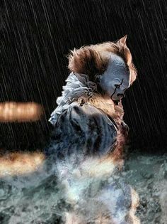 a creepy clown walking in the rain with his head turned to look like he's crying